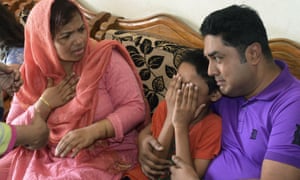 young son of Mahmuda Begum is comforted as he cries