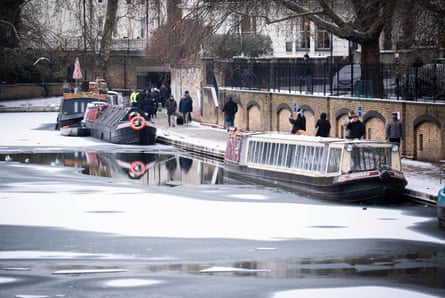 People walk beside an icy canal in London