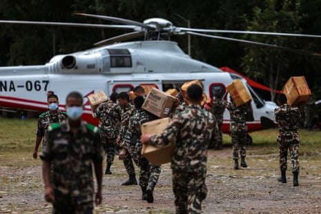 Members of the Nepali Army load relief material into a helicopter
