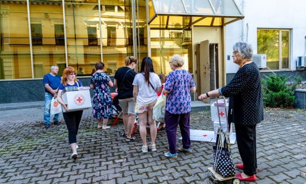 Internally displaced people collect their food and hygiene package in Kyiv.