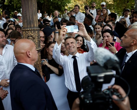 French president Emmanuel Macron takes a selfie with members of the public after the annual Bastille Day military parade on the Place de la Concorde in Paris, France.