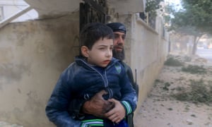 A rescue worker holds an injured boy after what activists said were airstrikes carried out by Russia in Idlib