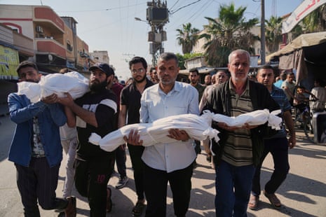 Palestinian carry the bodies of their relatives including children who were killed by an Israeli army airstrike in Deir al-Balah, 21 May.