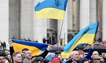 People wave Ukrainian flags in St Peter's Square in Rome as Pope Francis addresses the crowd, 10 March 2024