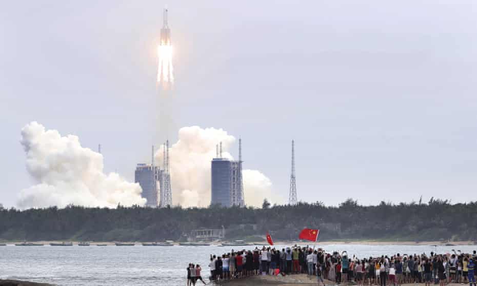 People watch the launch of the Long March 5B rocket from the Wenchang, Hainan province.