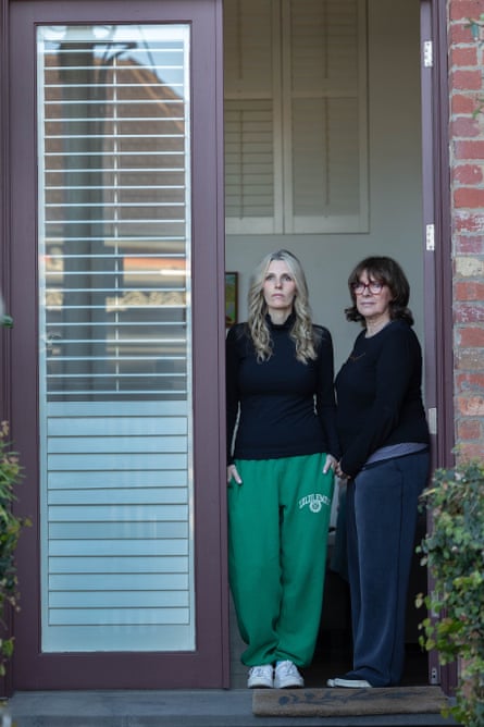 Laura and Gail stand together in a doorway, looking seriously at the camera