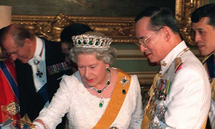 Britain’s Queen Elizabeth II looks at gifts presented to her by Thai King Bhumibol Adulyadej before a state banquet held in her honour at the Grand Palace in Bangkok, 28 October, 1996.