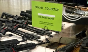 A gun seller at the Great Southern Gun and Knife Show in Atlanta advertises the fact that his customers are not subject to background checks.