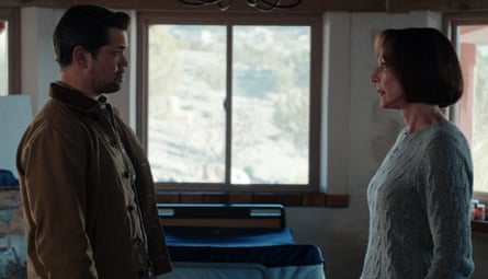 A man and a woman standing in a room looking at each other