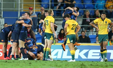 The Pumas celebrate the win as the Wallabies look dejected.