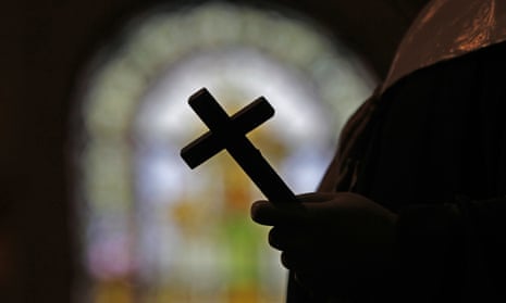 Cross in silhouette against stained glass window
