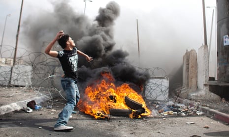 A Palestinian man throws stones at Israeli soldiers during unrest at Qalandia in September.