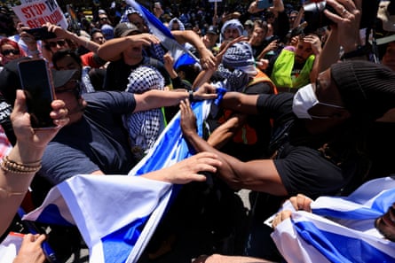 two groups of people face each other and appear to yell and extend their hands