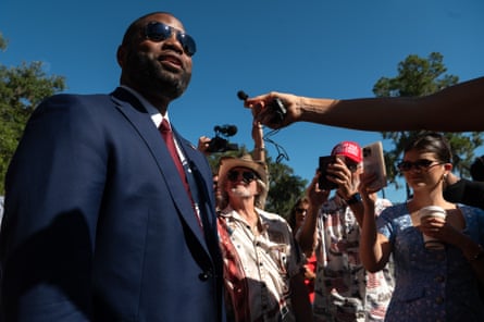 Byron Donalds, in sunglasses and a suit, speaks to media at a campaign event