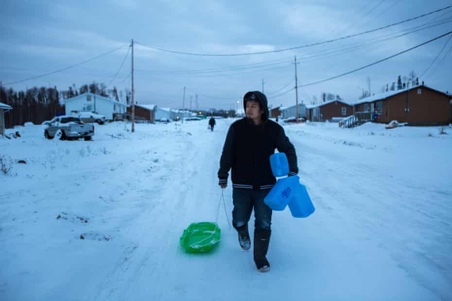 Ashley Sakanee walks home with three jugs of water that he filled up at the community’s osmosis machine, in Neskantaga First Nation in Northern Ontario. He said he makes 3 or 4 trips a week to fetch water for drinking, cooking and bathing.