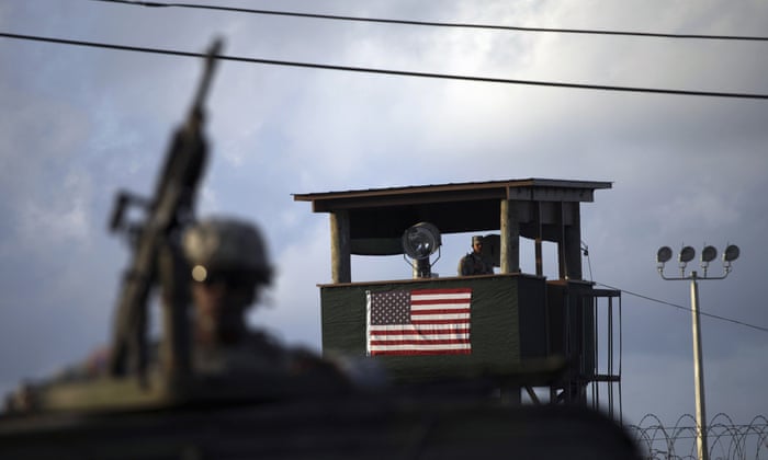 A US trooper mans a machine gun as a guard looks out from a tower in front of the detention facility at Guantanamo Bay.