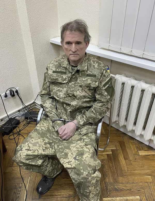 Medvedchuk in handcuffs and dressed in an army uniform.