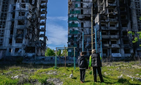 People look at an apartment building destroyed by Russian attacks in the city of Borodyanka, north-west of Kyiv, of Saturday