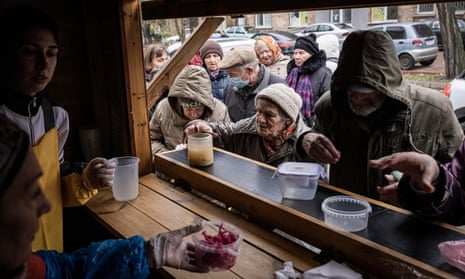 Pensioners queue up for free soup, bread and hot food handed out at a stand run by a charity in Kyiv, Ukraine.
