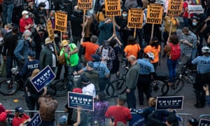 Police stand between two opposing groups of protesters outside the Philadelphia convention center, where officials were counting mail-in ballots.
