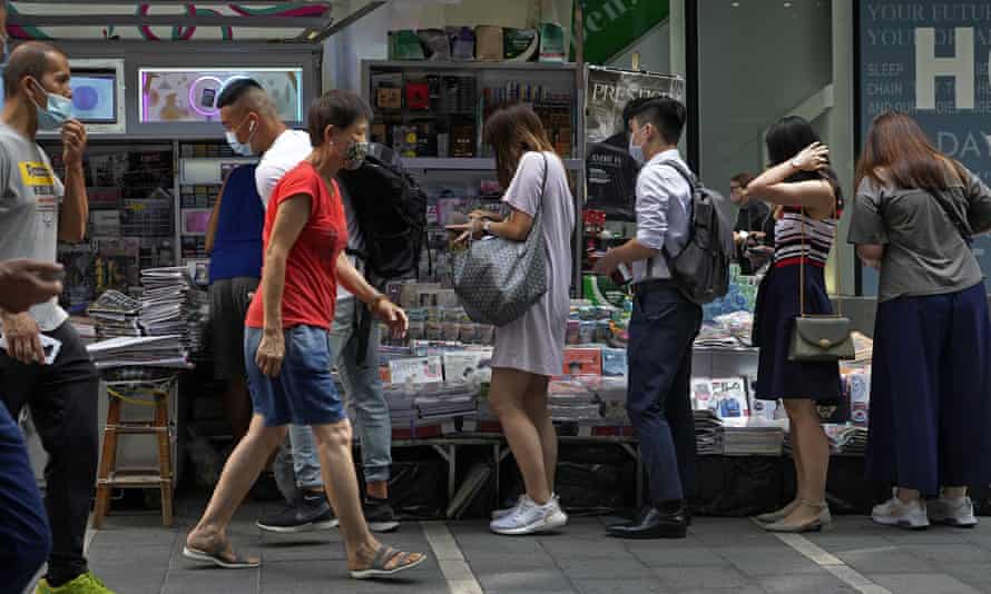 People queue up to buy the Apple Daily newspaper in downtown Hong Kong