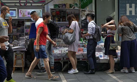 People queue up to buy the Apple Daily newspaper in downtown Hong Kong 