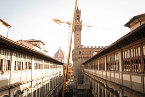 A large yellow crane in a street of historic buildings