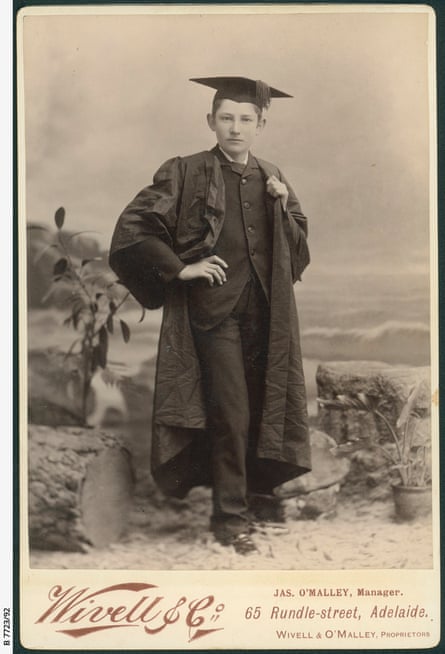 A young teen boy in a gown and mortarboard attending a Halloween ball