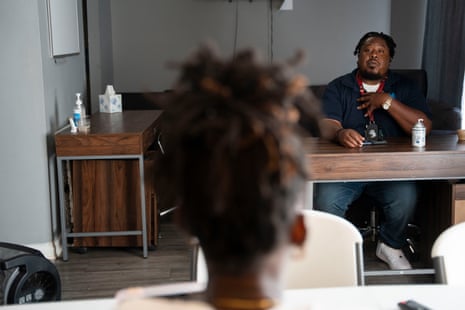 Workers speak to each other in an office.