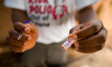 A man holds a vial containing polio vaccine during an immunization campaign.