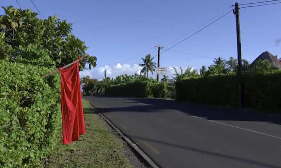 Red flags hang outside homes in Samoa where families are requesting vaccination against measles. 