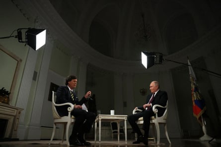 Two men speak while seated.