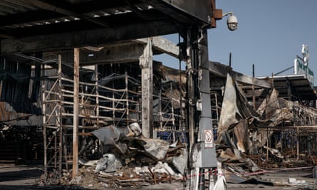 Destroyed shopping mall with lots of twisted metal and only the frame of its frontage remaining