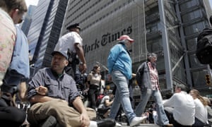 Activists sit on an intersection as others are taken into custody by police officers outside the New York Times building.