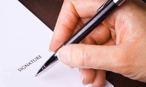 A hand with a pen signing a document