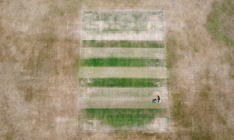 A groundsman at Boughton and Eastwell Cricket Club in Kent works on a hot, dry wicket