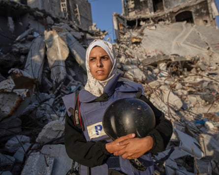 Mariam Dagga in front of a destroyed building