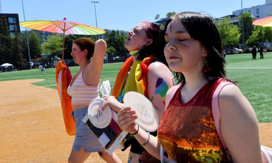 Frances Wilson, Claire Kilga and Raven Seydlitz participate in the Capitol Hill Pride march in soaring heat in Seattle on Saturday.