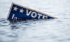 A campaign sign is partially submerged in floodwaters caused by Hurricane Matthew