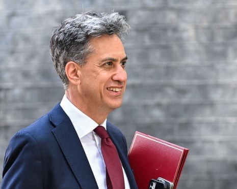 Ed Miliband leaves 10 Downing Street: he is smiling and carrying a red folder.