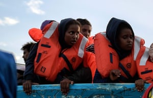 Migrants wait to be rescued as they drift in a boat