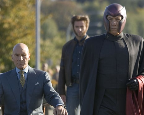 a man in a suit in a wheelchair and a man in black with a red helmet