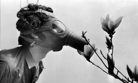 A Pace College student in a gas mask “smells” a magnolia blossom in City Hall Park on Earth Day in 1970 in New York. (AP Photo)