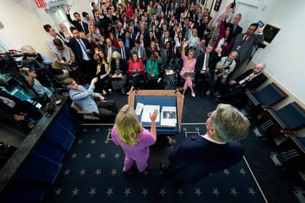 a woman at a podium addresses a room of seated people