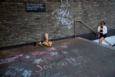 woman walks up stairs to street near bouquets and chalk writing saying ‘rest in peace’ and other messages to Neely
