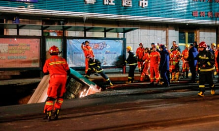 Chinese rescuers prepare to lift a bus out of the ground after the road collapse in Xining.