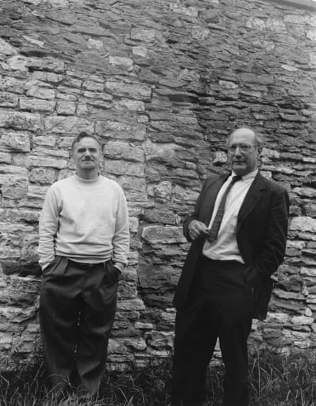 Two men stand next to a dry-stone wall