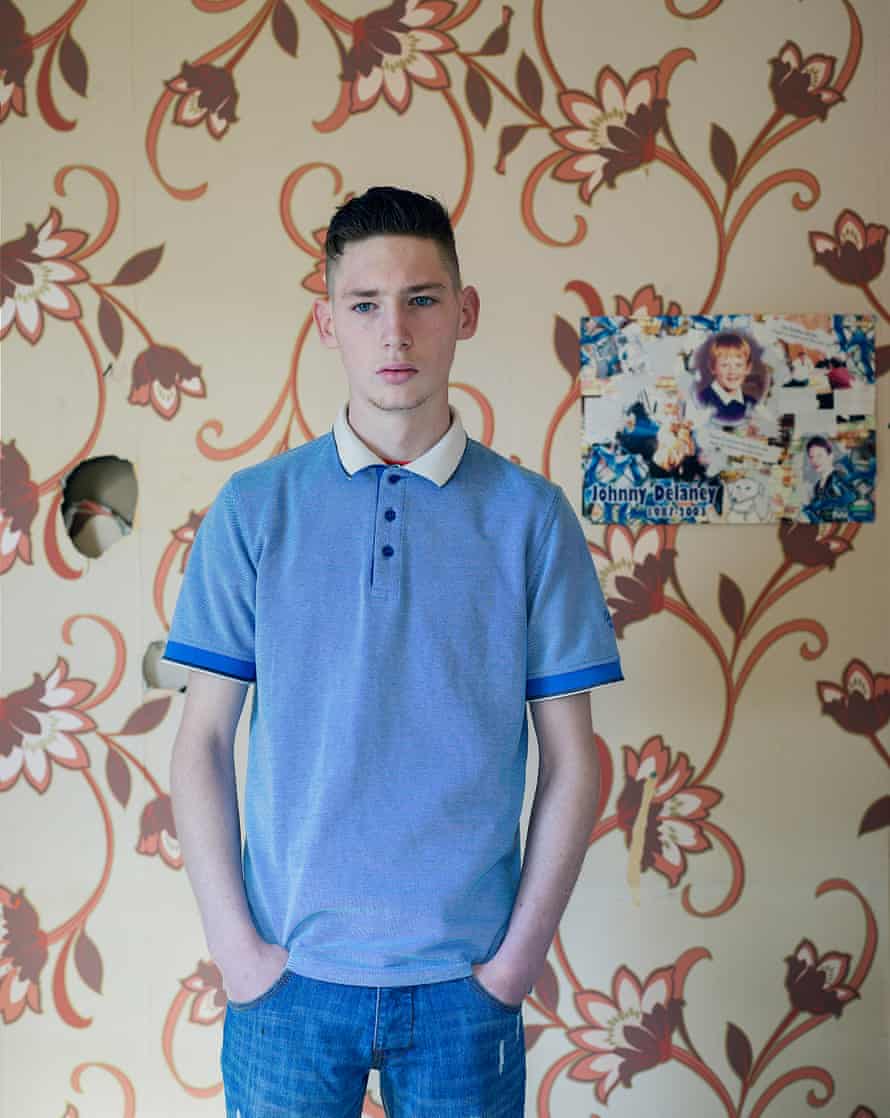 Paddy, 16, standing in front of patterned wallpaper