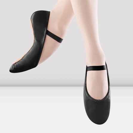 A woman wears black ballet shoes pointing her feet