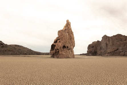 A lone standing rock on an empty beach